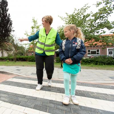 Verkeersoouders helpen kinderen met oversteken