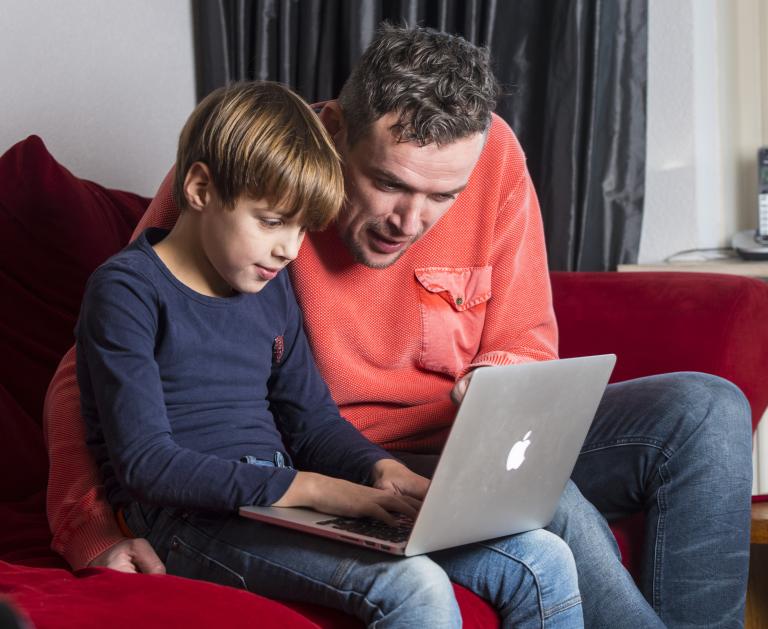 Vader en zoon oefenen verkeersexamen thuis